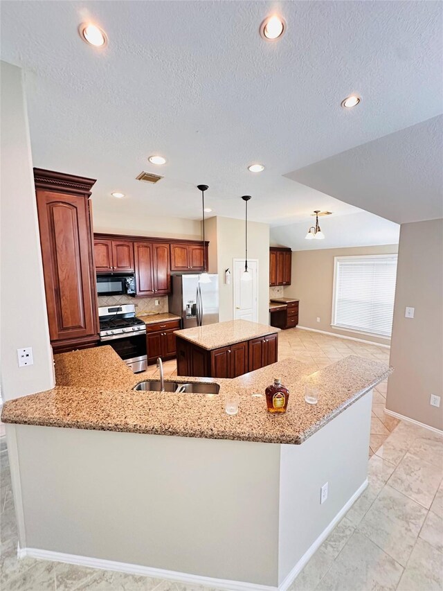 4306 Dow Way, Pasadena, TX 77505 - kitchen with appliances with stainless steel finishes, a sink, a center island, light stone counters, and a textured ceiling