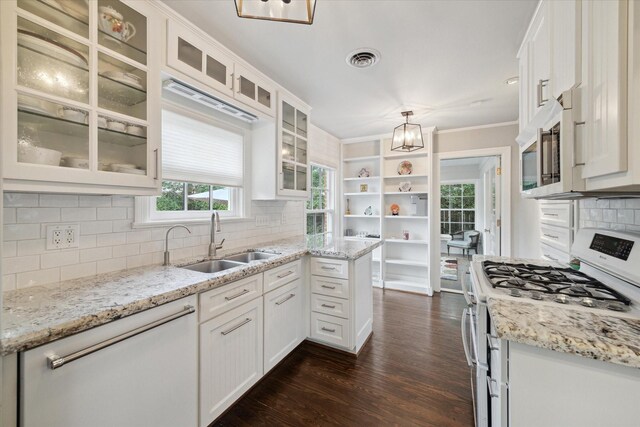 4006 University Blvd, West University Place, TX 77005 - kitchen with white range with gas cooktop, a sink, a chandelier, stainless steel microwave, and white cabinets