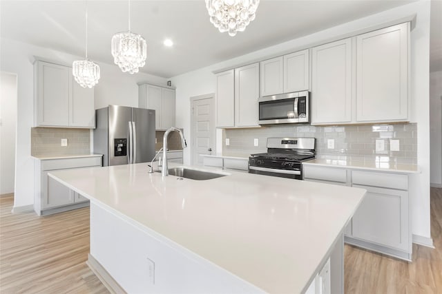 3434 Harper Meadow Ln, Missouri City, TX 77459 - kitchen featuring appliances with stainless steel finishes, a chandelier, a sink, an island with sink, and recessed lighting