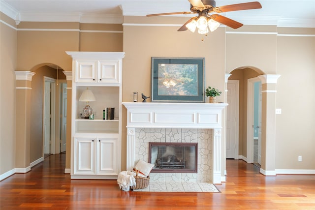 1818 Janell Rene Cir, Deer Park, TX 77536 - unfurnished living room with arched walkways, crown molding, wood finished floors, a ceiling fan, and a tile fireplace