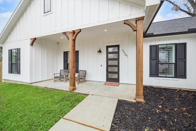 25747 Beaver Run Dr, Huffman, TX 77336 - view of exterior entry featuring board and batten siding, a shingled roof, a yard, and covered porch