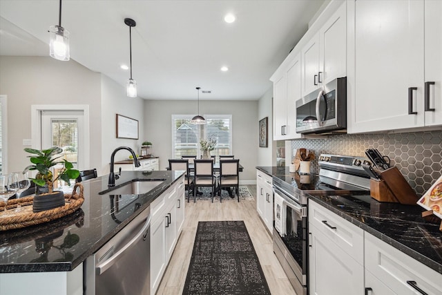 25747 Beaver Run Dr, Huffman, TX 77336 - kitchen featuring stainless steel appliances, a sink, recessed lighting, light wood-type flooring, and backsplash