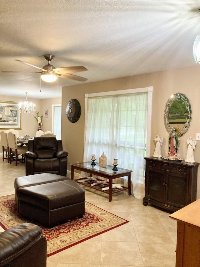 157 Rolling Hills Dr, Conroe, TX 77304 - living room with a chandelier, ceiling fan, a textured ceiling, and light tile patterned floors