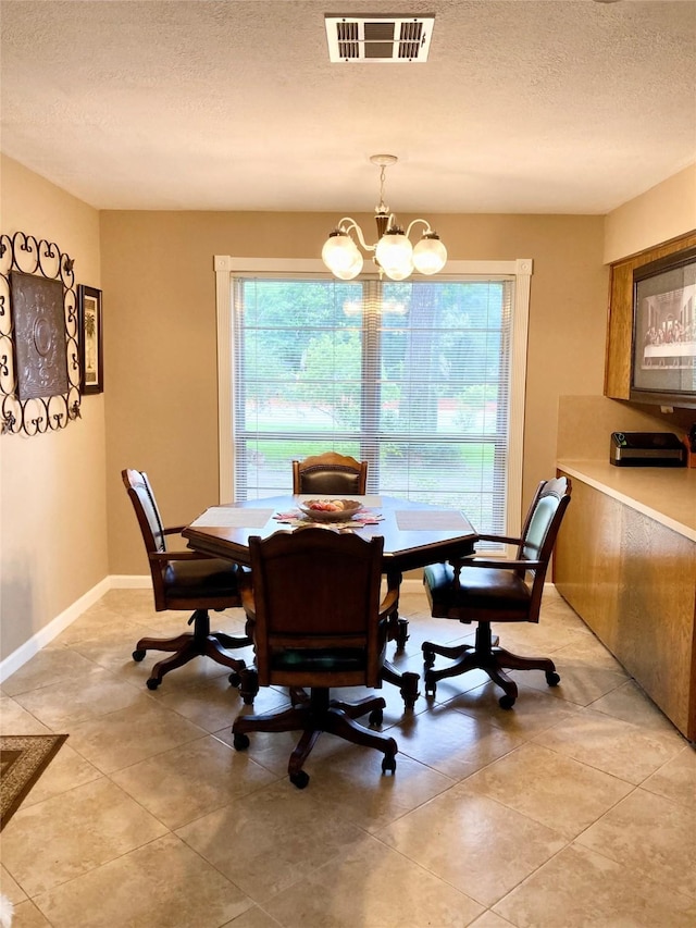 157 Rolling Hills Dr, Conroe, TX 77304 - dining area featuring plenty of natural light, a textured ceiling, light tile patterned floors, a chandelier, and baseboards