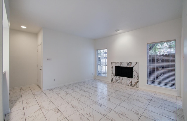1818 Augusta Dr Unit 3, Houston, TX 77057 - unfurnished living room with plenty of natural light, marble look tile flooring, a fireplace, recessed lighting, and baseboards