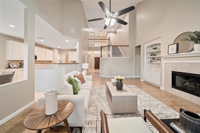 22519 Diamond Shore Ct, Katy, TX 77450 - living room with high vaulted ceiling, built in features, ceiling fan, a tiled fireplace, and baseboards