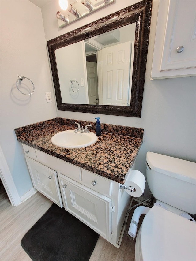 7900 Westheimer Rd Unit 255, Houston, TX 77063 - bathroom with vanity, wood finished floors, toilet, and baseboards