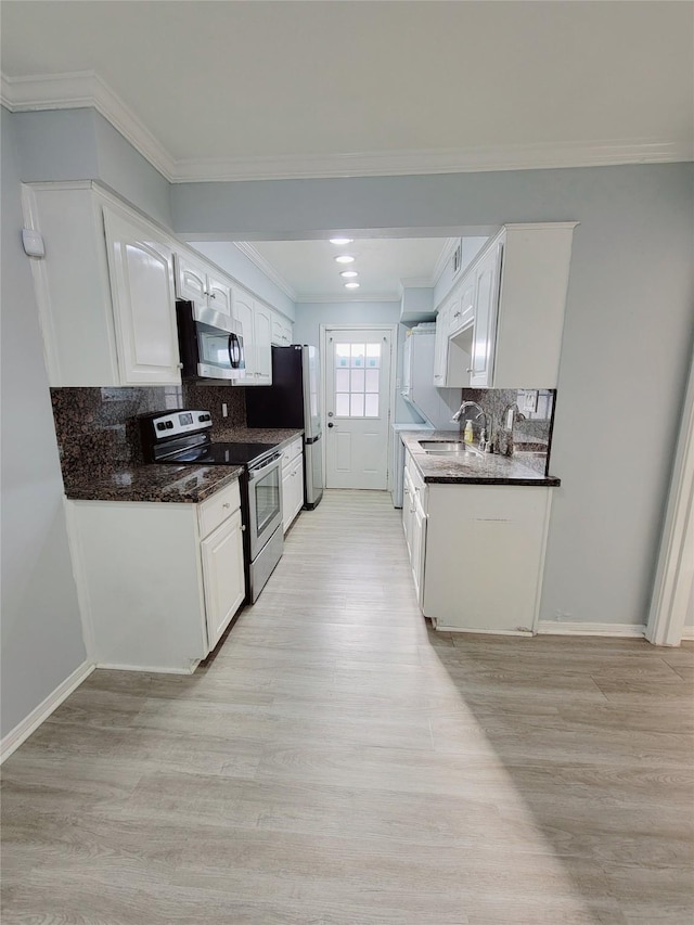 7900 Westheimer Rd Unit 255, Houston, TX 77063 - kitchen featuring stainless steel appliances, white cabinetry, backsplash, light wood finished floors, and a sink