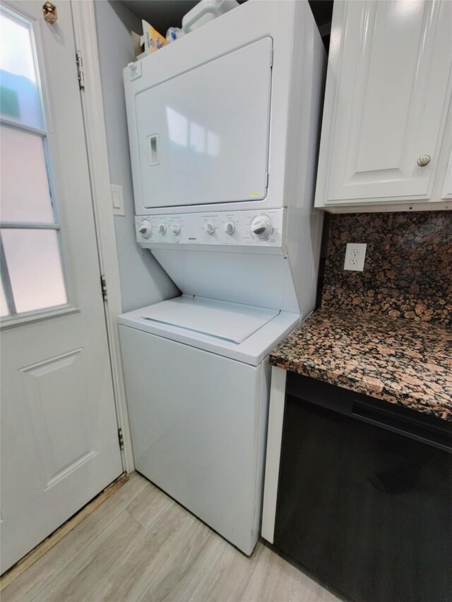 7900 Westheimer Rd Unit 255, Houston, TX 77063 - laundry area featuring stacked washer / drying machine, light wood-style flooring, and cabinet space