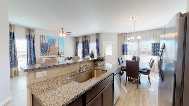 10288 Badger Run Ln, Magnolia, TX 77354 - kitchen with appliances with stainless steel finishes, a sink, a chandelier, and light wood finished floors