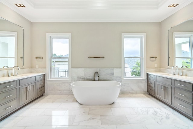 4613 Maple St, Bellaire, TX 77401 - bathroom featuring tile walls, crown molding, two vanities, a wainscoted wall, and a soaking tub