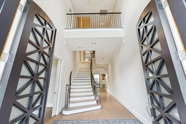 4613 Maple St, Bellaire, TX 77401 - foyer entrance with a high ceiling, baseboards, wood finished floors, arched walkways, and stairway