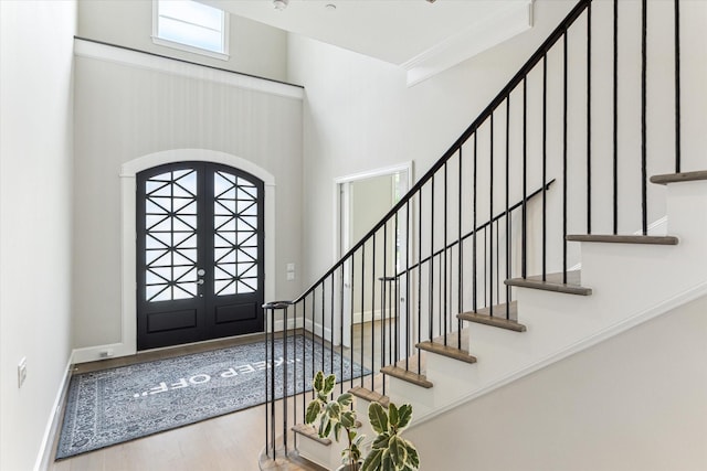 4613 Maple St, Bellaire, TX 77401 - foyer entrance featuring wood finished floors, a high ceiling, stairs, baseboards, and arched walkways