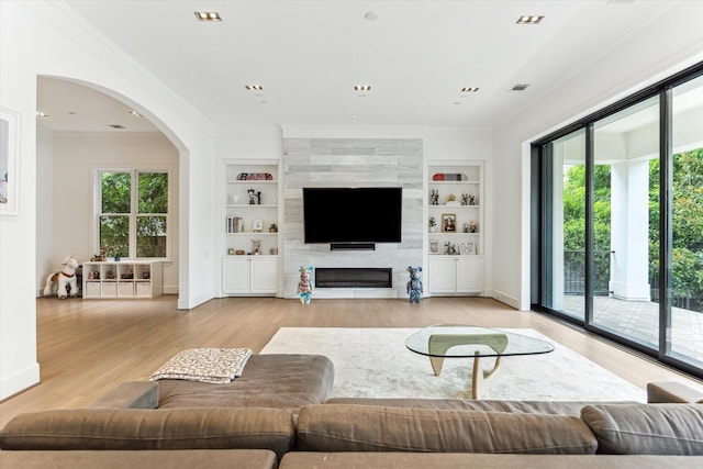4613 Maple St, Bellaire, TX 77401 - living room featuring crown molding, healthy amount of natural light, and built in features