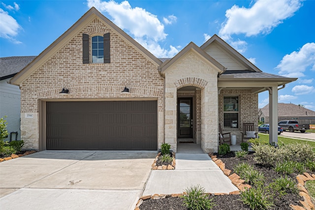19443 Pacers Gait Ln, Tomball, TX 77377 - french country home featuring driveway, brick siding, a shingled roof, a garage, and stone siding