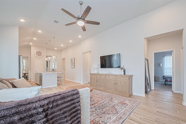 19443 Pacers Gait Ln, Tomball, TX 77377 - living room with a ceiling fan, healthy amount of natural light, light wood finished floors, baseboards, and high vaulted ceiling