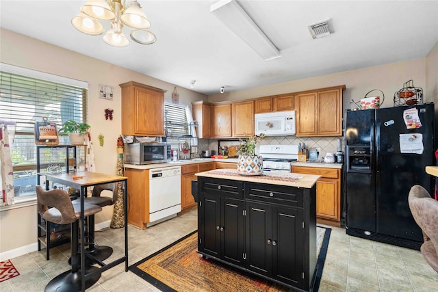 24235 Stargazer Pt, Spring, TX 77373 - kitchen featuring white appliances, dark cabinets, light countertops, a chandelier, and decorative backsplash