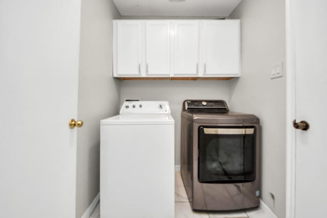 8707 Tartan Walk Ln, Houston, TX 77075 - laundry room featuring washer and clothes dryer, cabinet space, baseboards, and light tile patterned floors
