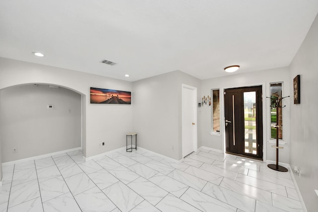 8707 Tartan Walk Ln, Houston, TX 77075 - foyer featuring light marble finish floors, arched walkways, recessed lighting, and baseboards