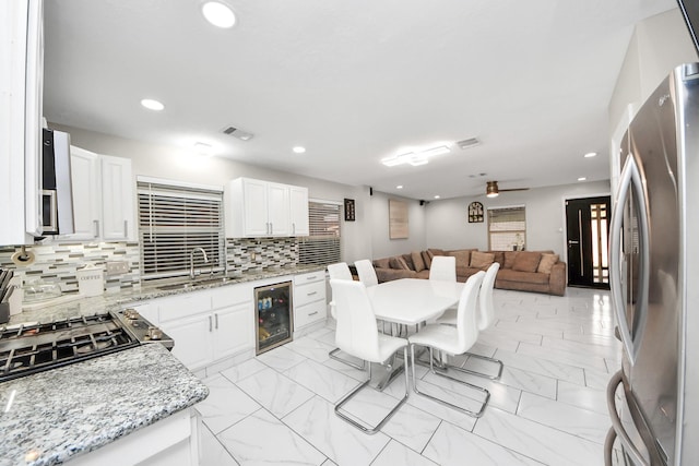 8707 Tartan Walk Ln, Houston, TX 77075 - kitchen featuring freestanding refrigerator, beverage cooler, a sink, open floor plan, and tasteful backsplash