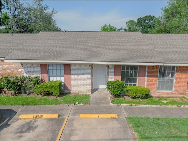 1965 Campbell Rd Unit 1965, Houston, TX 77080 - view of front of property with brick siding, a shingled roof, and uncovered parking
