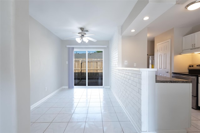 1965 Campbell Rd Unit 1965, Houston, TX 77080 - kitchen featuring stainless steel electric range oven, under cabinet range hood, ceiling fan, light tile patterned flooring, and white cabinetry