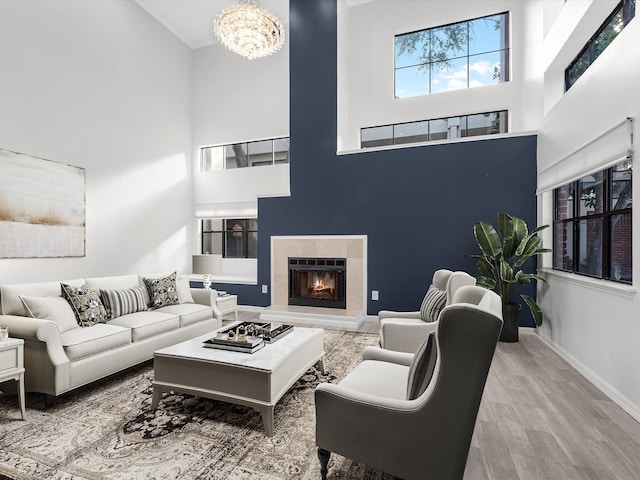 2464 Bering Dr Unit 2464, Houston, TX 77057 - living room with a towering ceiling, baseboards, a chandelier, wood finished floors, and a tiled fireplace