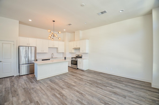 9414 Kerrwood Ln Unit B, Houston, TX 77080 - kitchen featuring stainless steel appliances, a sink, a chandelier, light wood-style floors, and recessed lighting