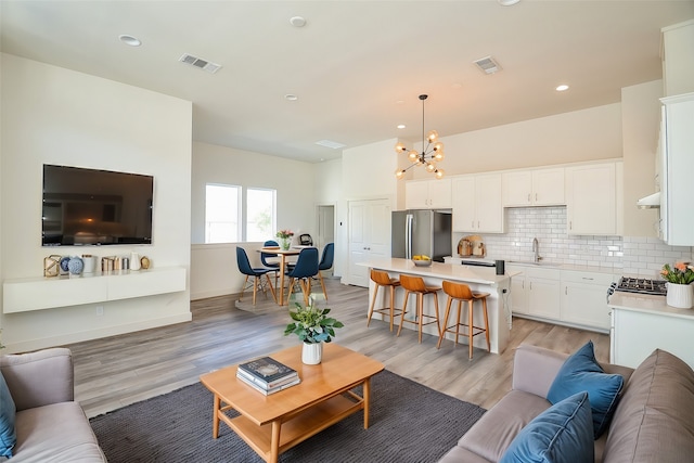 9414 Kerrwood Ln Unit B, Houston, TX 77080 - living room featuring a chandelier, light wood finished floors, and recessed lighting