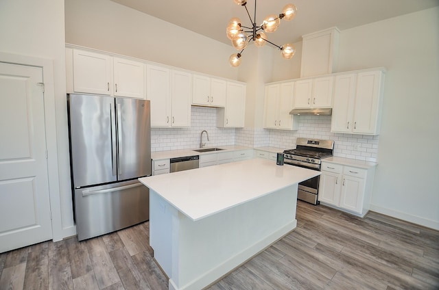 9414 Kerrwood Ln Unit B, Houston, TX 77080 - kitchen featuring stainless steel appliances, a sink, under cabinet range hood, a chandelier, and white cabinets