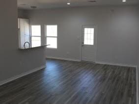 2352 Cedar Place Dr, Conroe, TX 77306 - unfurnished living room with baseboards and dark wood-style flooring