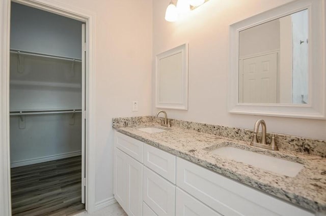 2352 Cedar Place Dr, Conroe, TX 77306 - bathroom featuring double vanity, baseboards, and a spacious closet