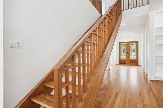 4521 Palmetto St, Bellaire, TX 77401 - staircase featuring french doors, a high ceiling, wood finished floors, recessed lighting, and baseboards