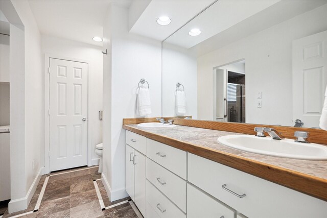4521 Palmetto St, Bellaire, TX 77401 - full bathroom featuring baseboards, double vanity, toilet, and recessed lighting