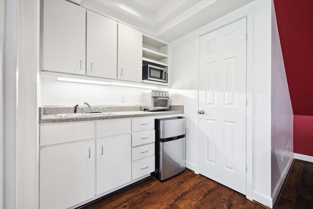 4521 Palmetto St, Bellaire, TX 77401 - kitchen with appliances with stainless steel finishes, open shelves, dark wood finished floors, white cabinets, and a sink