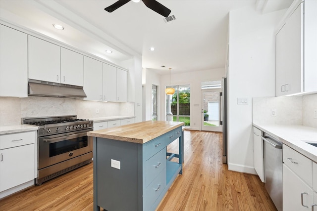 4521 Palmetto St, Bellaire, TX 77401 - kitchen with stainless steel appliances, under cabinet range hood, a ceiling fan, wood counters, and recessed lighting