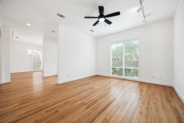 4521 Palmetto St, Bellaire, TX 77401 - empty room featuring light wood-type flooring, baseboards, track lighting, a chandelier, and a ceiling fan