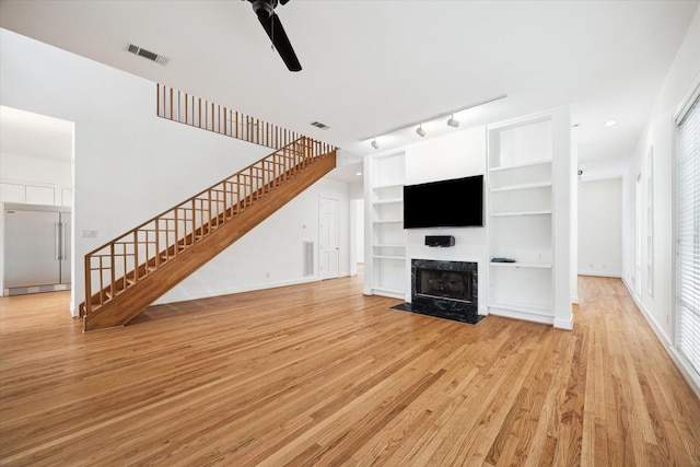 4521 Palmetto St, Bellaire, TX 77401 - unfurnished living room featuring stairway, ceiling fan, light wood-style floors, a fireplace with flush hearth, and recessed lighting