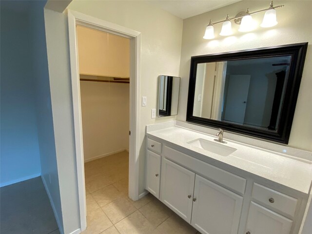 10123 Kent Towne Ln, Sugar Land, TX 77498 - bathroom featuring vanity, tile patterned flooring, a spacious closet, and baseboards