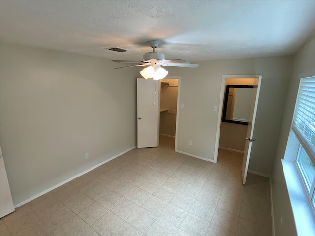 10123 Kent Towne Ln, Sugar Land, TX 77498 - unfurnished bedroom featuring a spacious closet, a closet, baseboards, and a ceiling fan