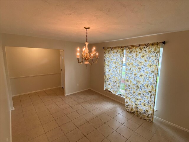 10123 Kent Towne Ln, Sugar Land, TX 77498 - unfurnished room featuring light tile patterned floors, a chandelier, and baseboards