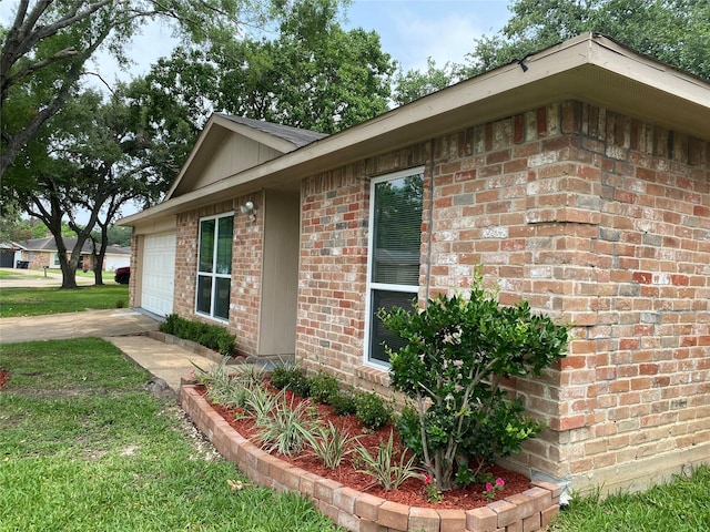 10123 Kent Towne Ln, Sugar Land, TX 77498 - view of side of home featuring brick siding, a garage, concrete driveway, and a lawn