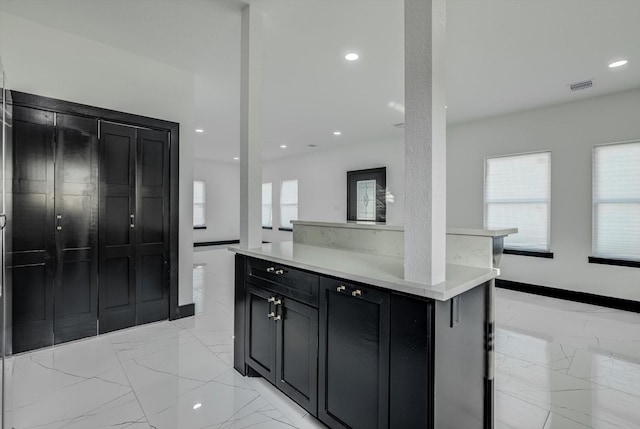 5911 Rietta, Houston, TX 77016 - kitchen featuring dark cabinets, light marble finish flooring, light countertops, and recessed lighting
