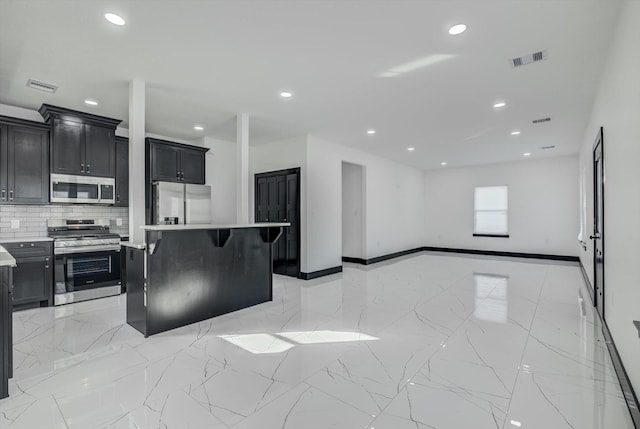 5911 Rietta, Houston, TX 77016 - kitchen with appliances with stainless steel finishes, tasteful backsplash, light countertops, a center island, and recessed lighting