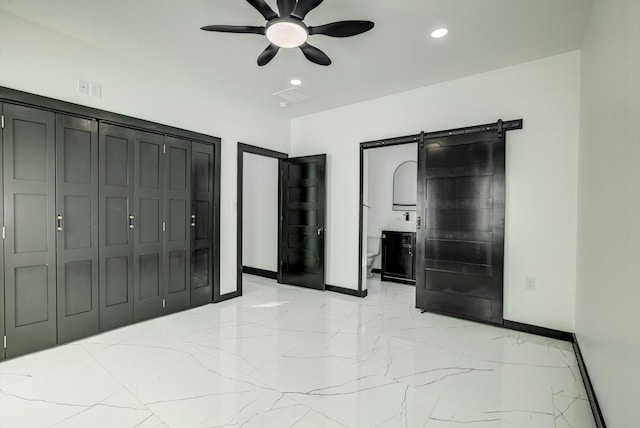 5911 Rietta, Houston, TX 77016 - unfurnished bedroom with a barn door, light marble finish floors, recessed lighting, ceiling fan, and a closet