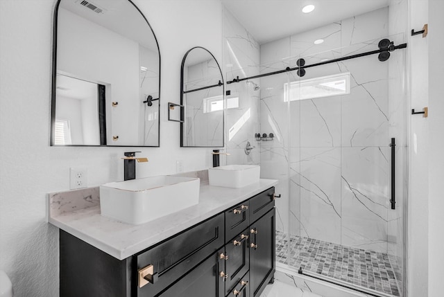 5911 Rietta, Houston, TX 77016 - full bathroom with double vanity, a marble finish shower, marble look tiles, and recessed lighting