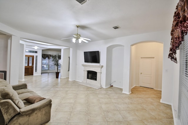 21323 Hannover Frst, Spring, TX 77388 - living room featuring ceiling fan, a fireplace with raised hearth, light tile patterned floors, and baseboards