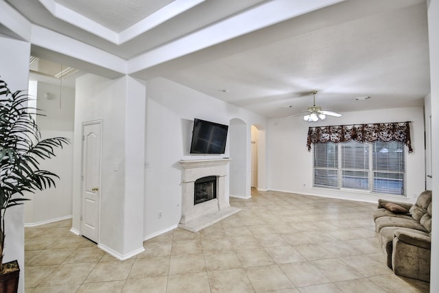 21323 Hannover Frst, Spring, TX 77388 - unfurnished living room with a ceiling fan, arched walkways, a fireplace, light tile patterned floors, and baseboards