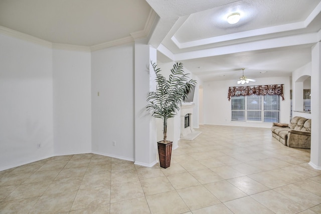21323 Hannover Frst, Spring, TX 77388 - unfurnished living room featuring light tile patterned flooring, ceiling fan, a fireplace with raised hearth, and a raised ceiling