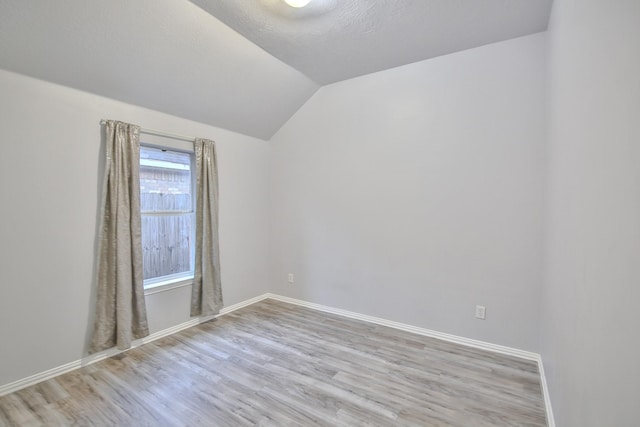 21323 Hannover Frst, Spring, TX 77388 - spare room featuring light wood-style floors, lofted ceiling, and baseboards